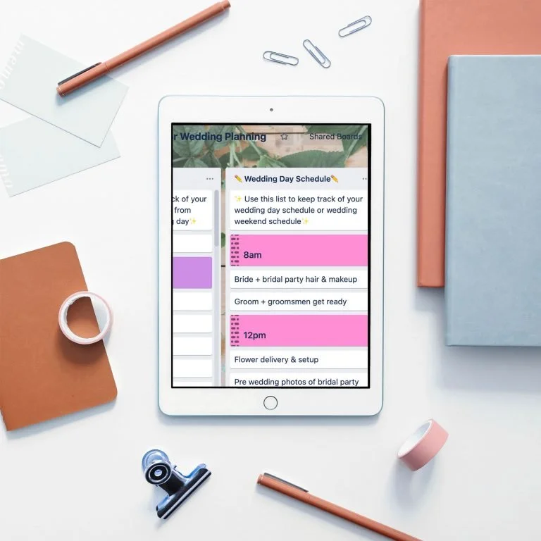Trello website on ipad screen sitting on desk with note pads, pens, and office supplies around it