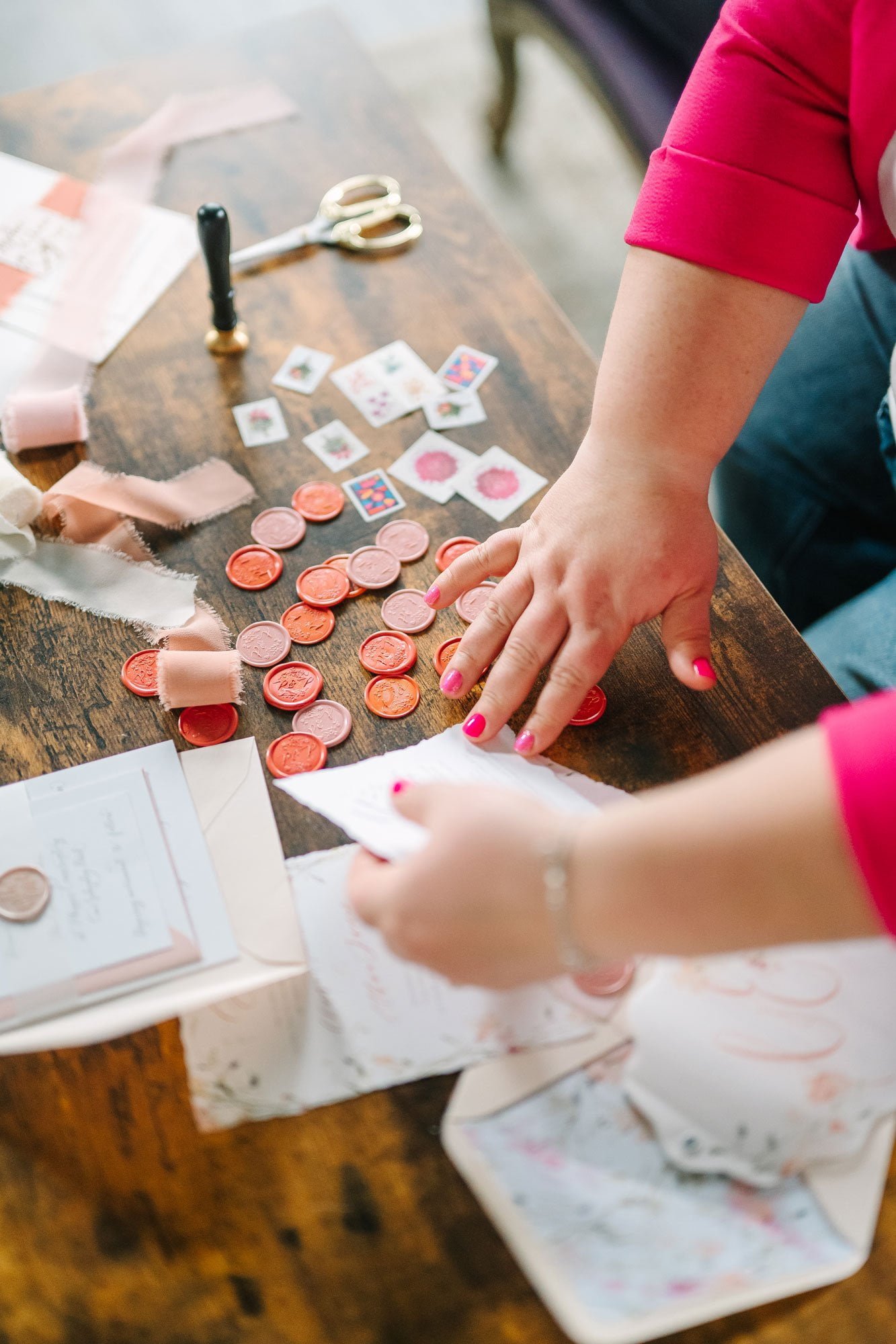 Hands holding stationery items on a brown table